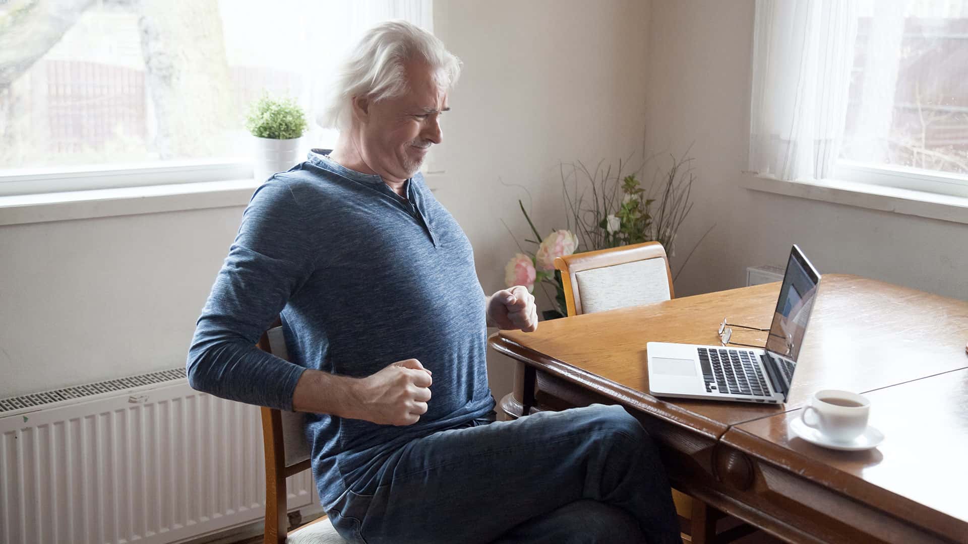 Man Stretching at Desk | What Are the Treatments for Spinal Stenosis