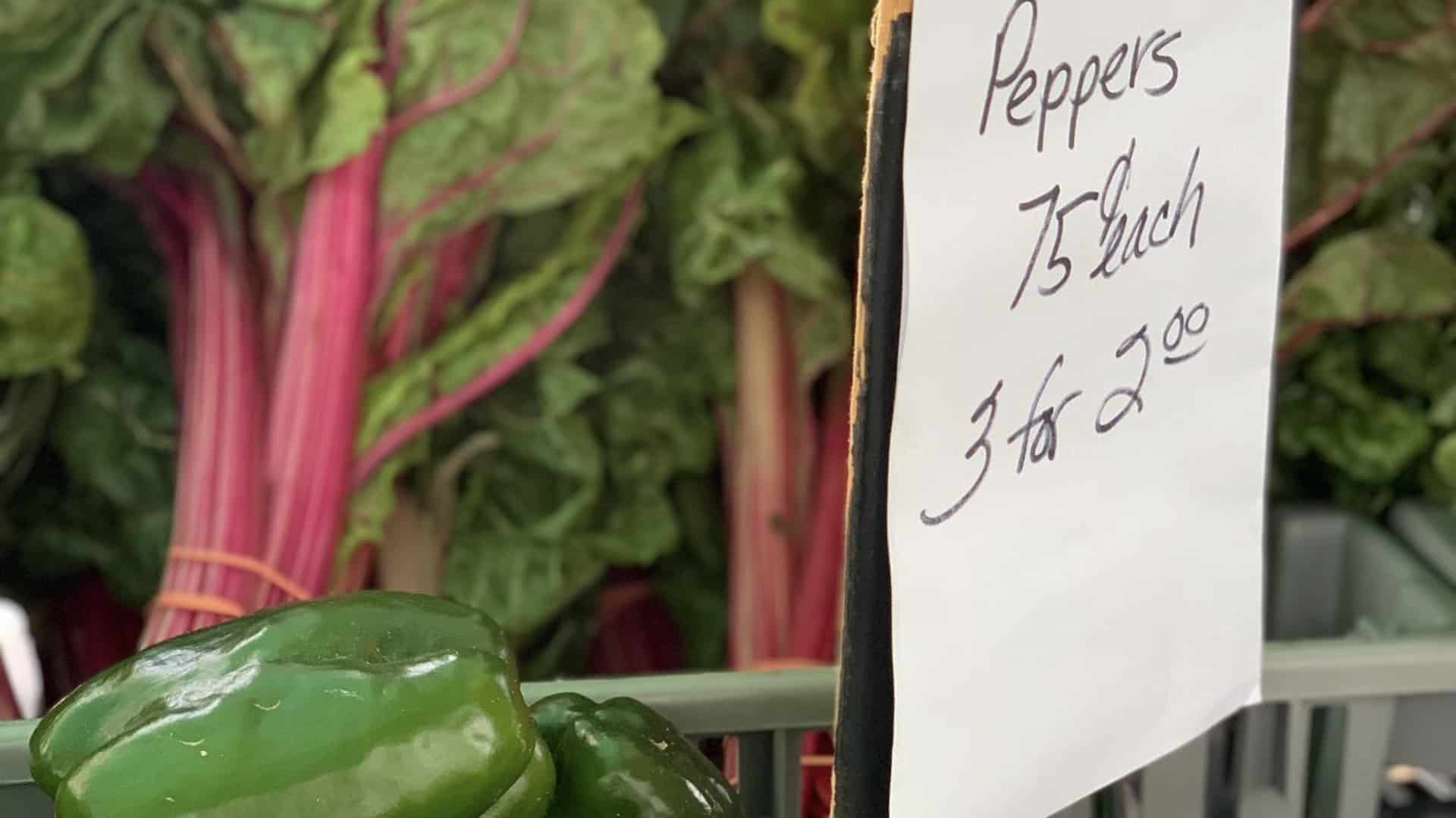 peppers with a sale sign stating, “Peppers 75 cents each 3 for $2