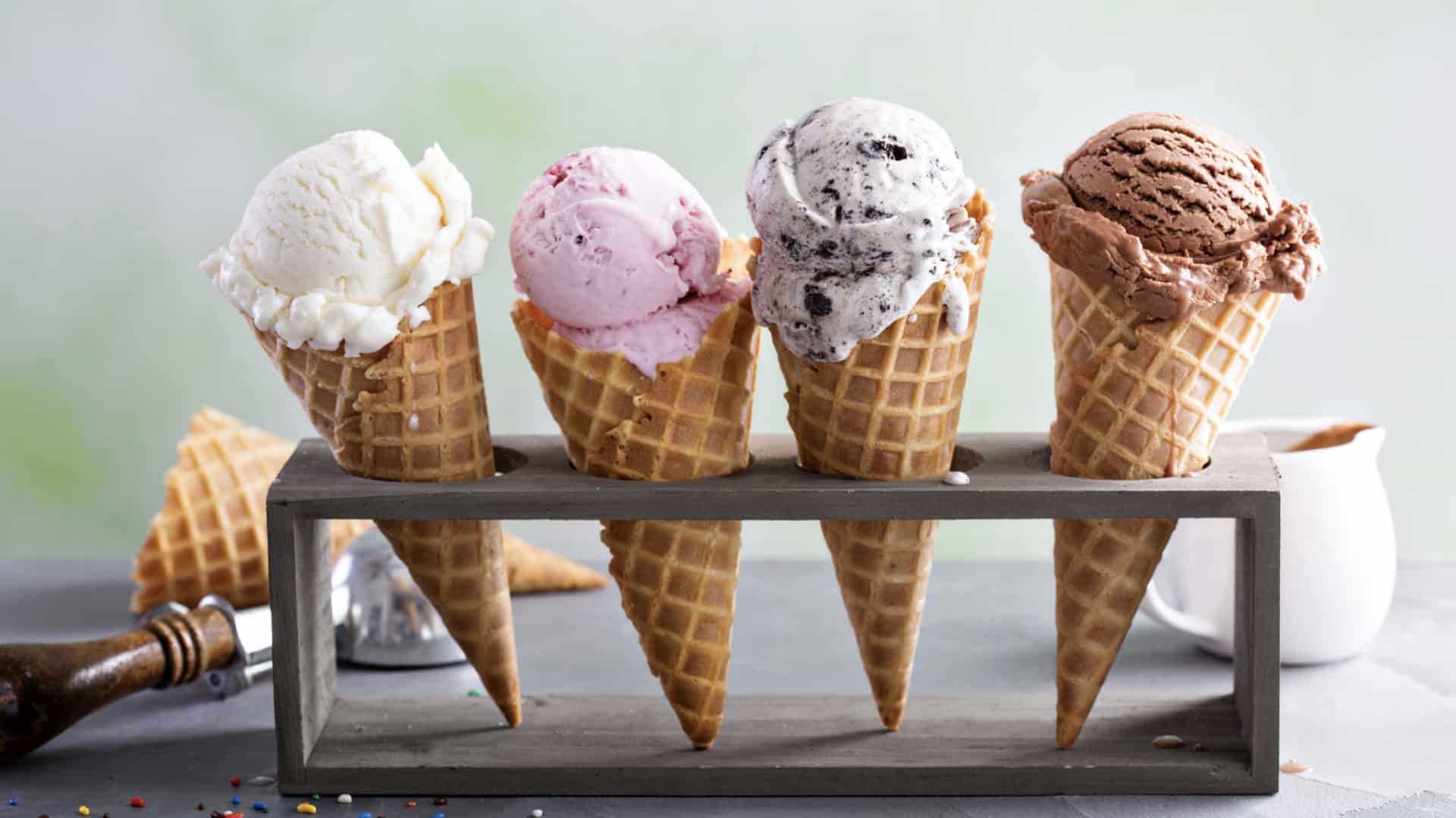 a variety of ice cream scoops in cones with chocolate, vanilla and strawberry