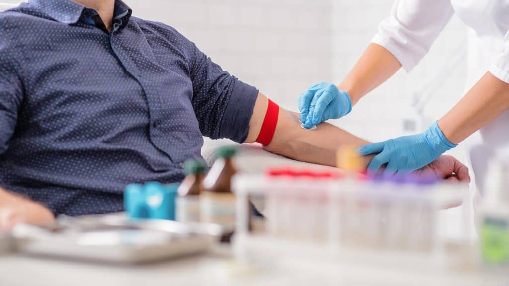 Do I have to have any tests before undergoing neurosurgery? A nurse disinfects a patient’s arm before performing blood work