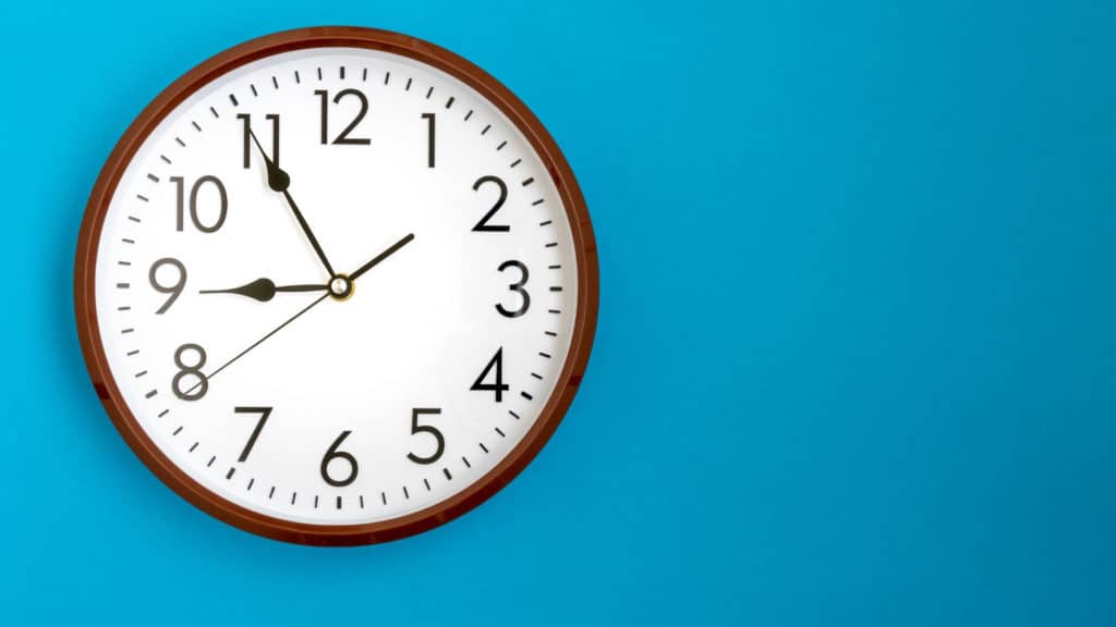 a wall clock displays on a blue wall