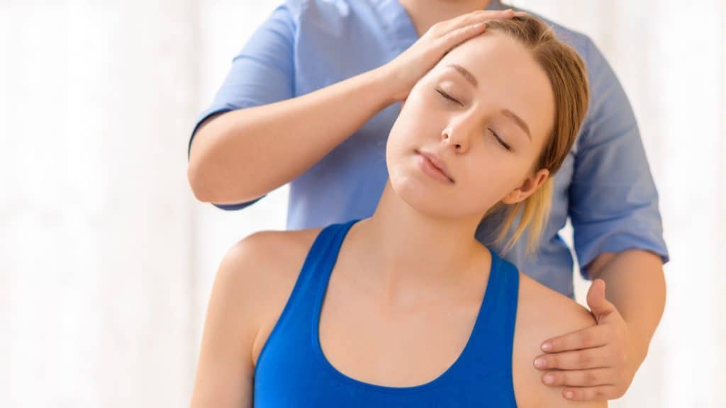 a happy patient gets their neck adjusted by a chiropractor