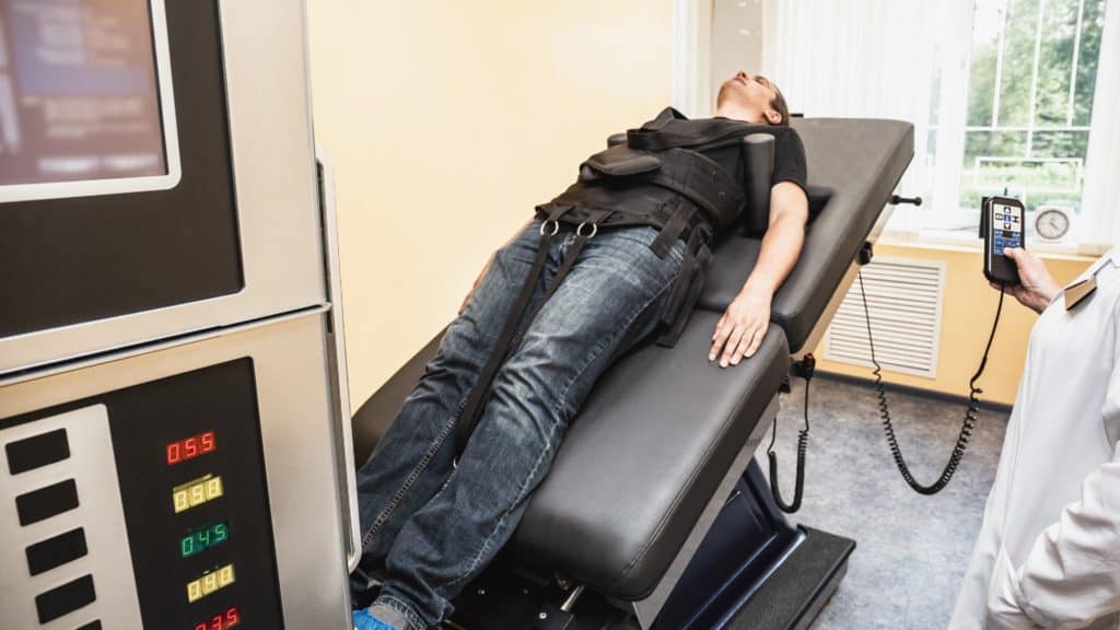 a person undergoes a spinal decompression procedure on a traction table