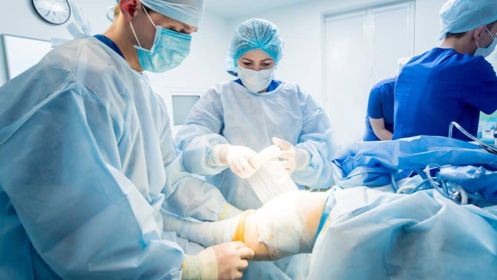doctors perform knee surgery