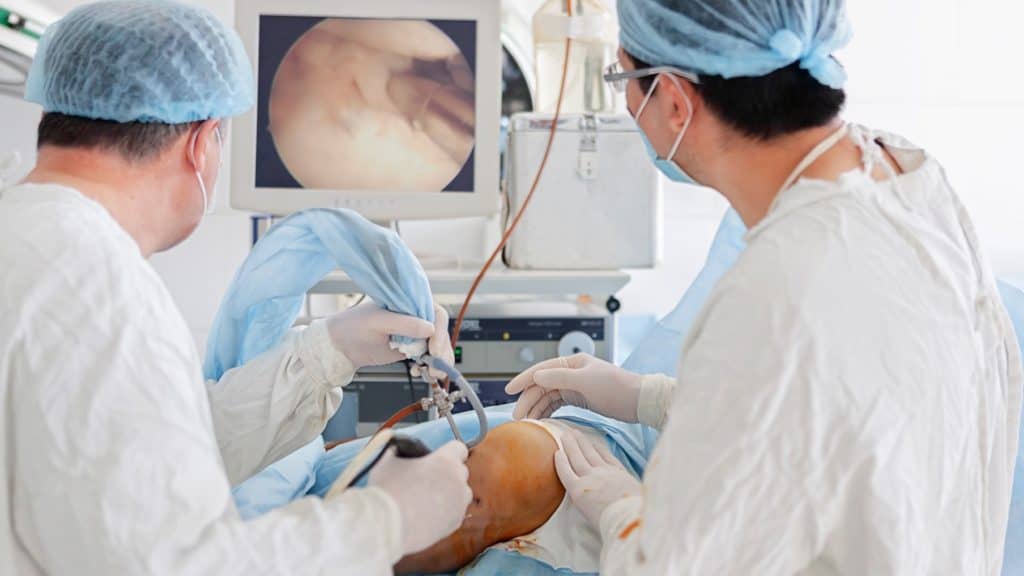 two doctors perform arthroscopy surgery