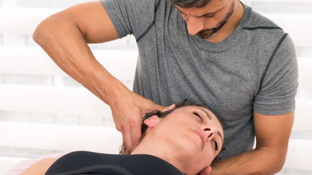 Chiropractor cracking woman’s neck | Can Chiropractors Fix Tech Neck? | Northeast Spine and Sports Medicine