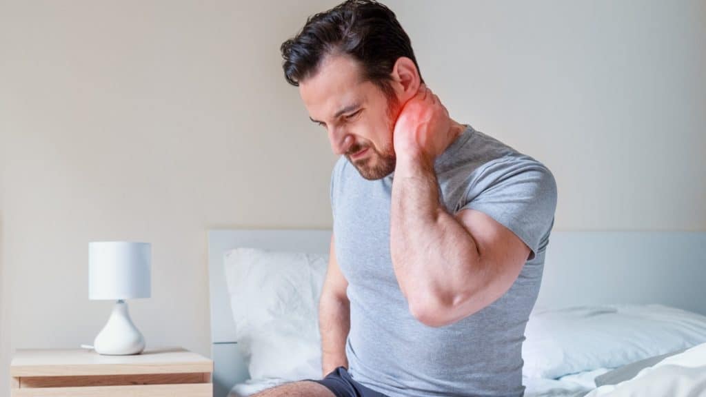 Man holding neck in pain | What Are the Symptoms of Tech Neck? | Northeast Spine and Sports Medicine