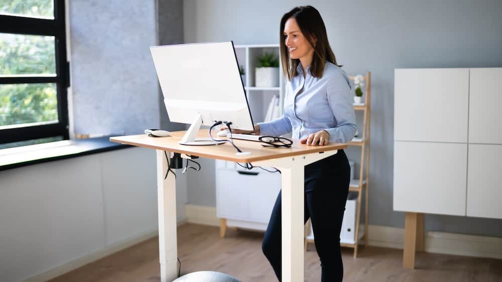 Woman using standing desk | Try a Standing Desk | Northeast Spine and Sports Medicine