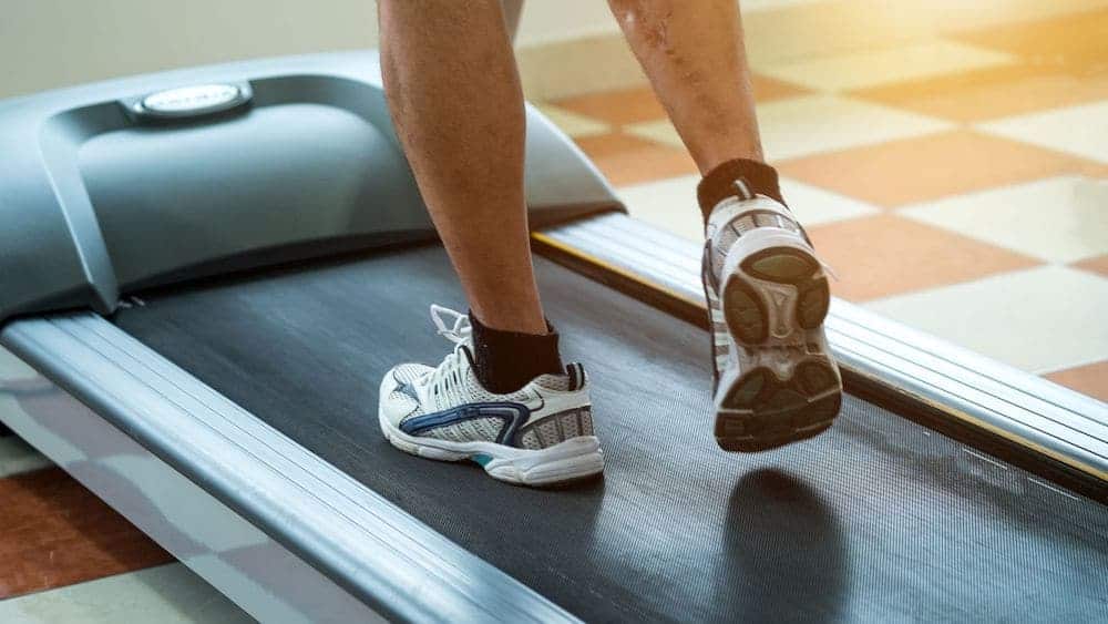 Close up of person running on a treadmill in sneakers | Northeast Spine and Sports Medicine
