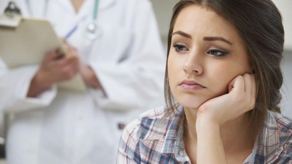 Close up of female patient sitting in front of physical therapist | NorthEast Spine and Sports Medicine