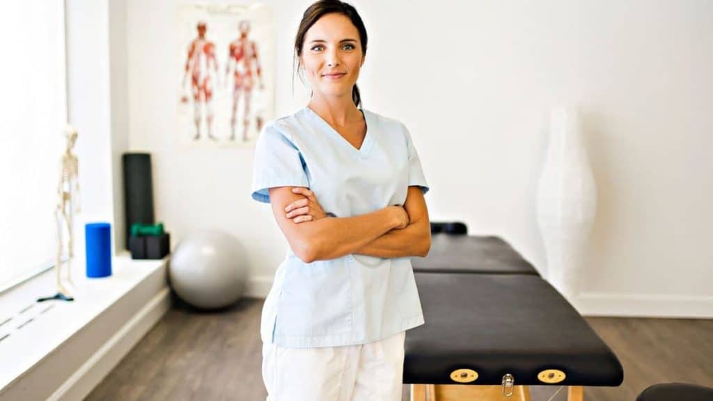 Female physical therapist standing in office with arms crossed | NorthEast Spine and Sports Medicine