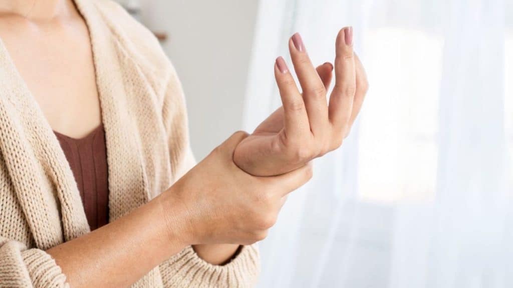 Close up woman holding her wrist in pain | NorthEast Spine and Sports Medicine
