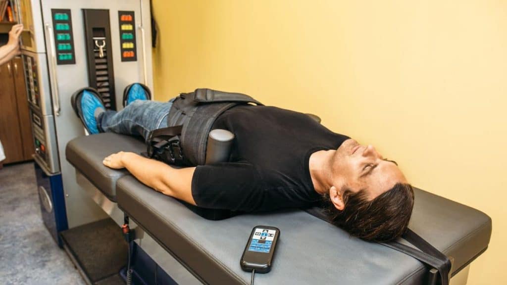 Chiropractor using machine to decompress patient's back | Back Pain Treatment at Northeast Spine and Sports Medicine