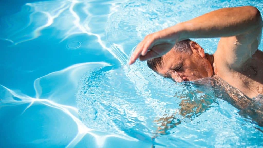 Close up of man swimming laps in pool | Back Pain Treatment at Northeast Spine and Sports Medicine