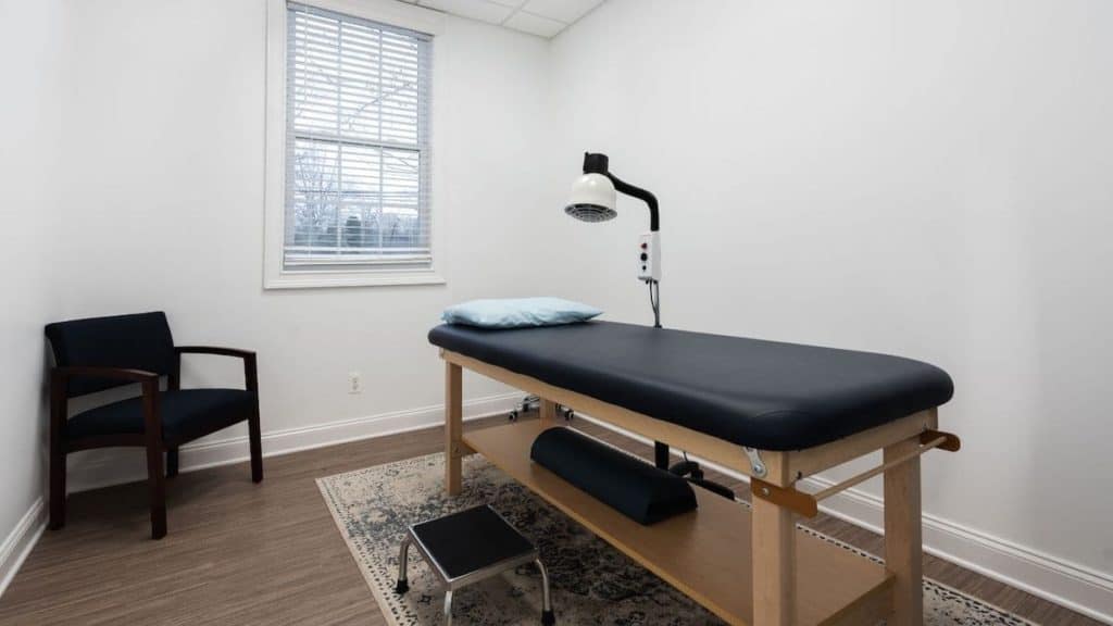 Empty exam room with table and chair for Physical Therapy at NorthEast Spine and Sports Medicine