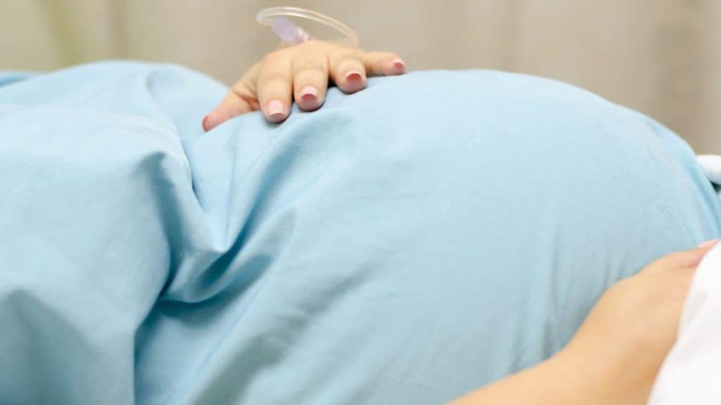 Expectant mother in labor on a hospital bed | Acupuncture at NorthEast Spine & Sports Medicine
