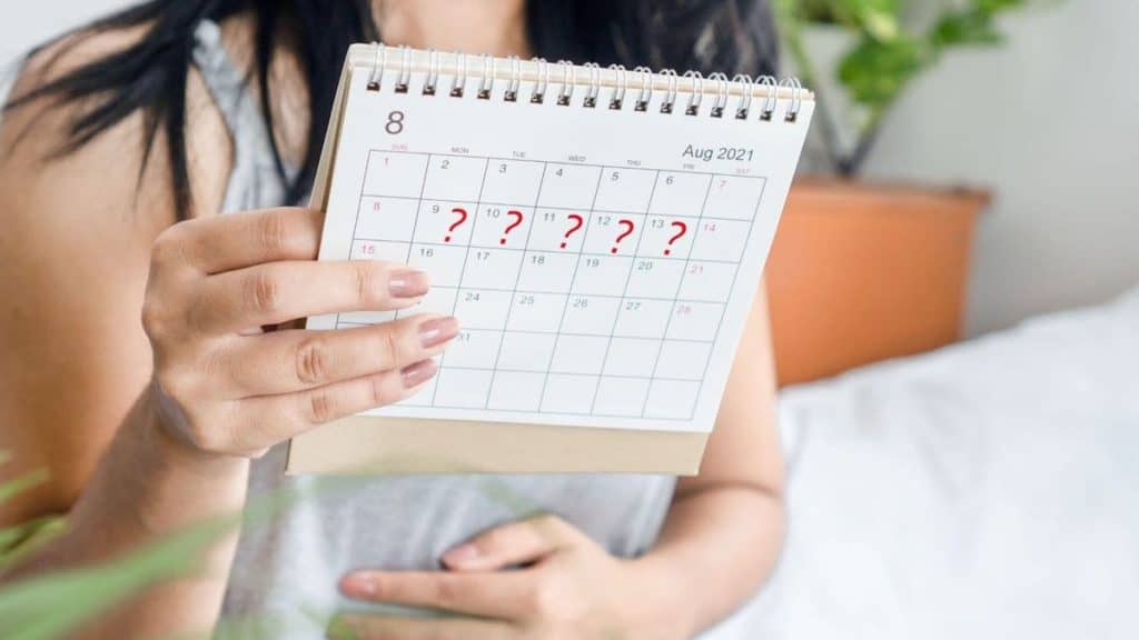 Stressed woman looks at calendar marked with question marks | Northeast Spine and Sports Medicine