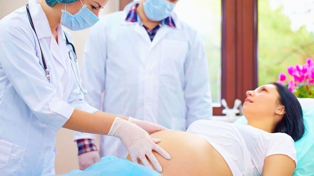Doctors examining a pregnant woman in labor | NorthEast Spine and Sports Medicine