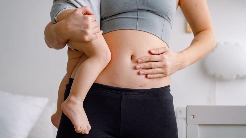 Postpartum woman holding her baby | Physical therapy at NorthEast Spine and Sports Medicine