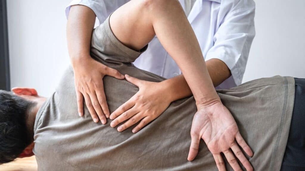 Chiropractor’s Hands Form Triangle As They Adjust Patient Spine | Chiropractor Statistics
